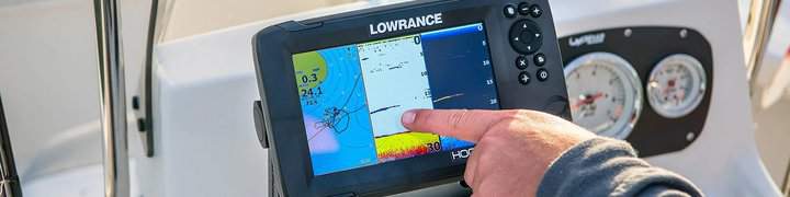 Angler using the fish finder on boat. Touching the screen and pointing at the sonar
